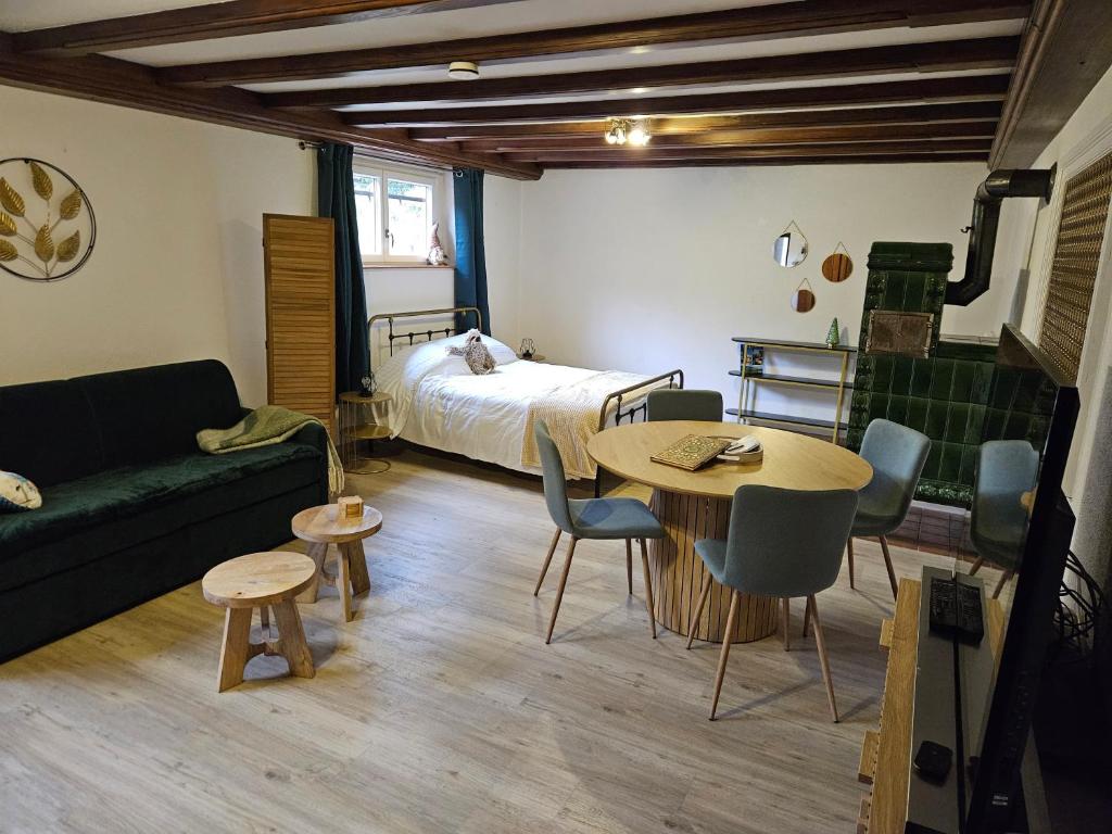 Habitación con cama, mesa y sofá en la Parenthèse Kaysersberg en Kaysersberg
