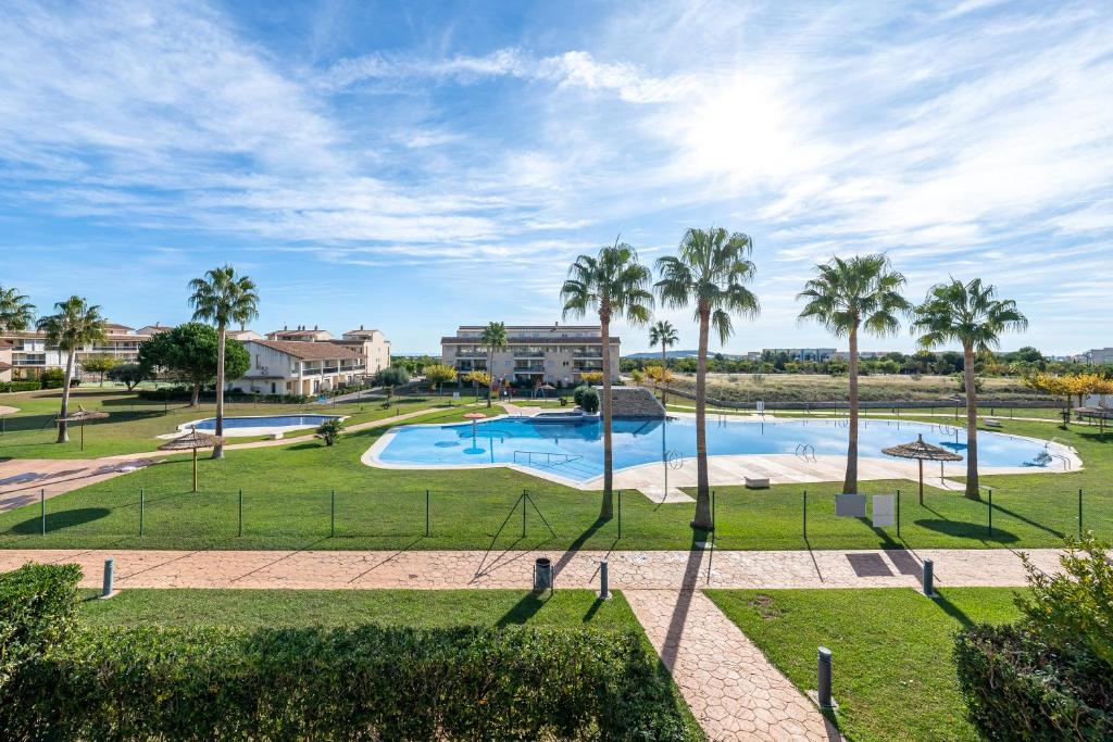 a swimming pool with palm trees in a park at Lujoso Chalet Golf Panoramica in San Jorge
