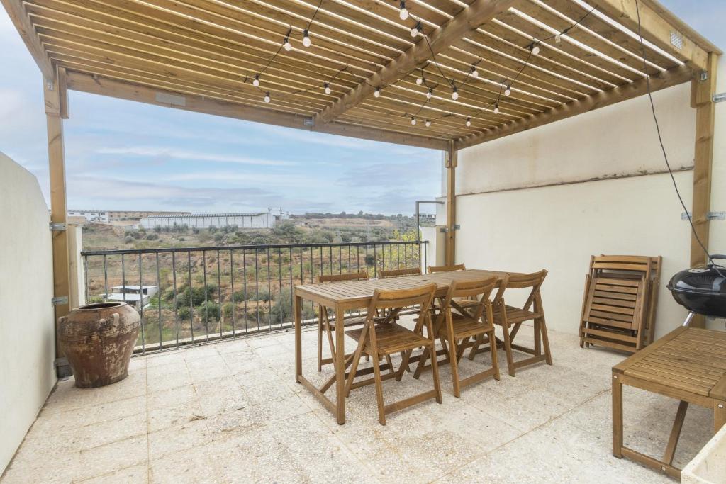 patio con mesa de madera y sillas en el balcón en Ca la Francesa, en Juncosa
