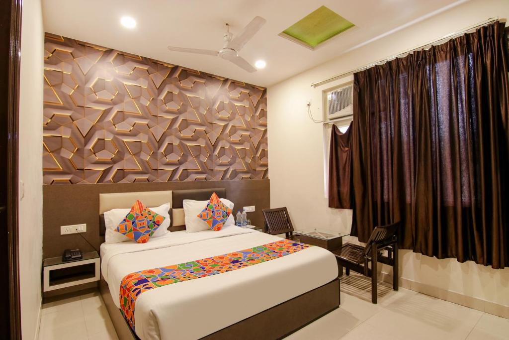 - une chambre avec un grand lit et une fenêtre dans l'établissement FabHotel Rosewood Inn, à Amritsar