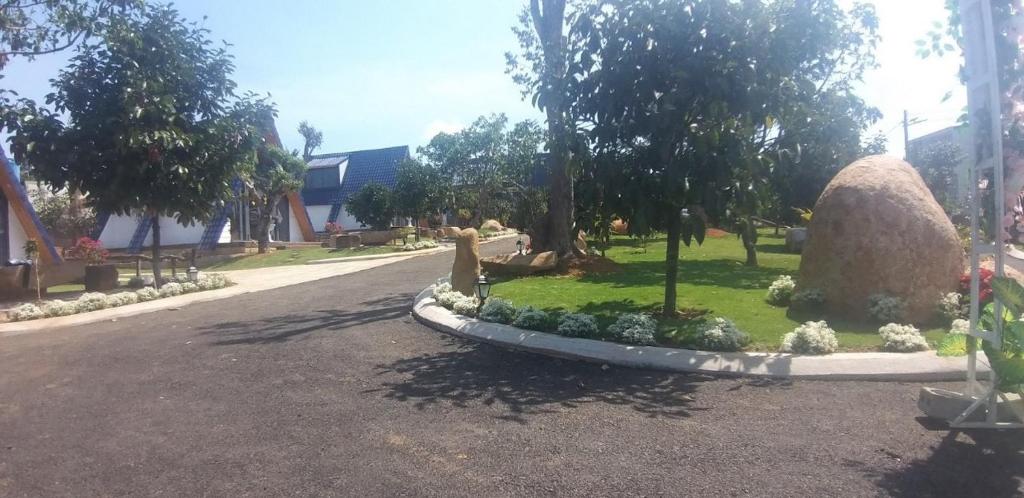 eine Straße mit einem Park mit Bäumen und Sträuchern in der Unterkunft Mộc Hoa Viên in Ấp Thiện Lập
