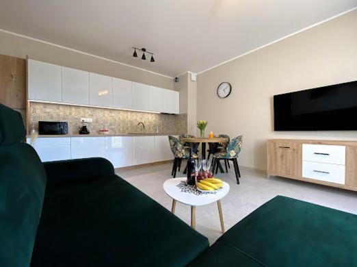 a living room with a couch and a table with bananas at Apartament Morski Wiatr in Ustronie Morskie