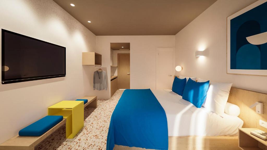 a hotel room with a blue bed and a tv at Cabot Playa Grande - Adults Only in Playa de Palma