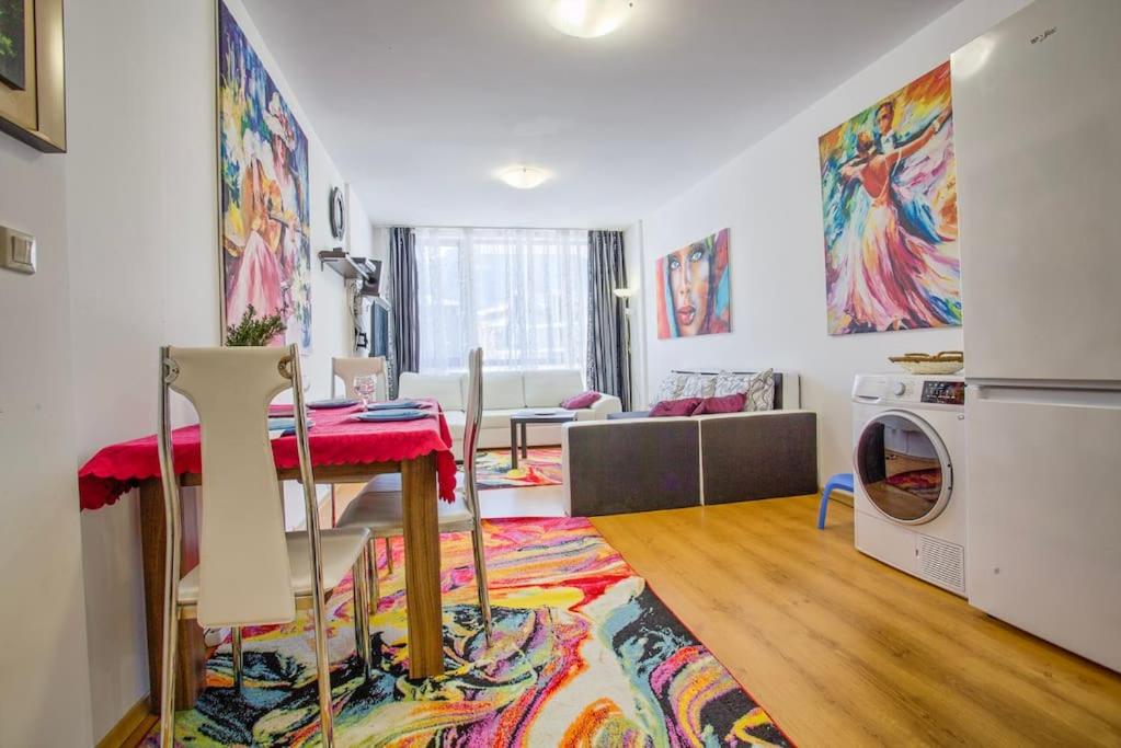 ein Wohnzimmer mit einem Tisch und einer Waschmaschine in der Unterkunft Lovely apartment in Aspen Golf Resort with SPA in Bansko