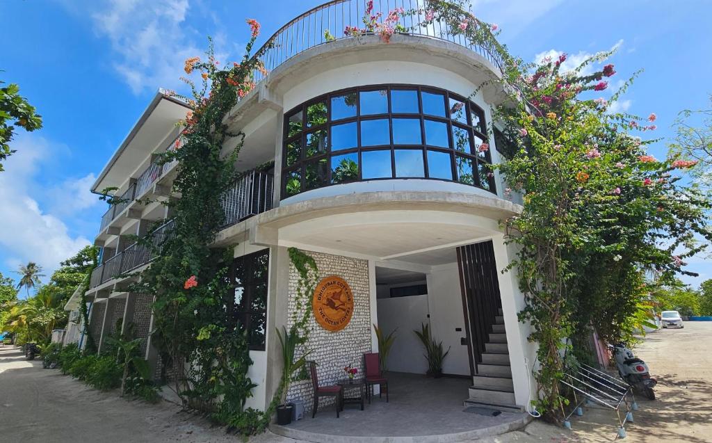 een gebouw met een balkon erboven bij Dhigurah Cottage in Dhigurah