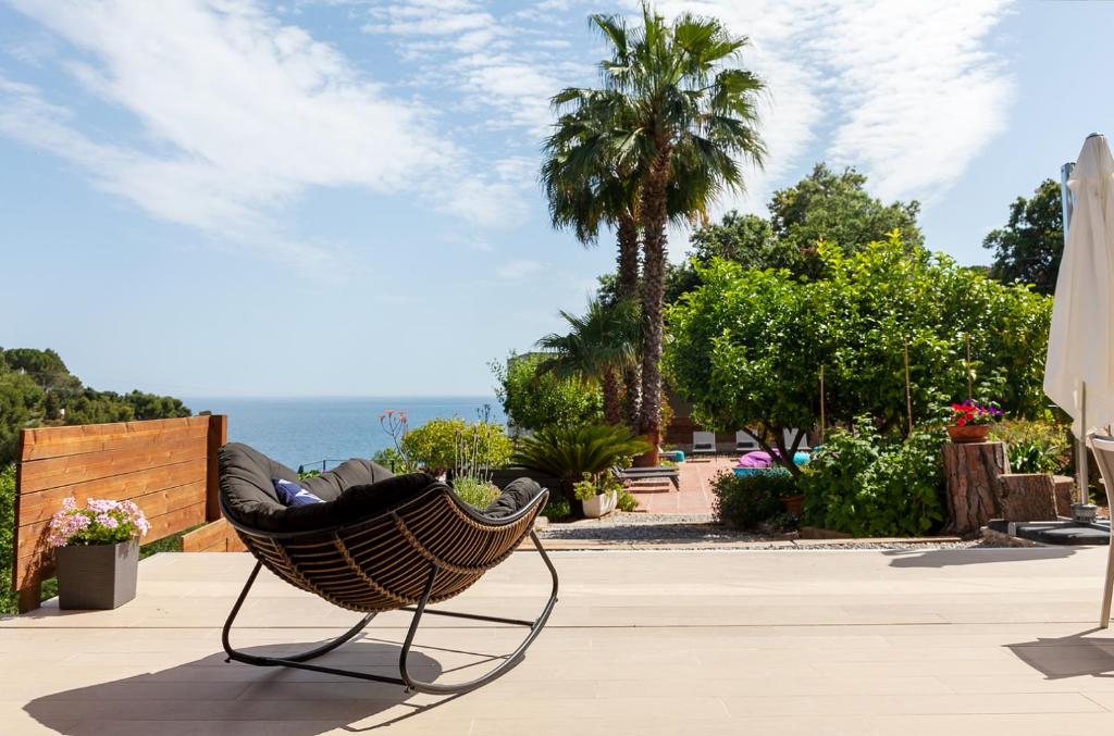 a chair sitting on a sidewalk next to the ocean at Casa KARIAN in Tossa de Mar