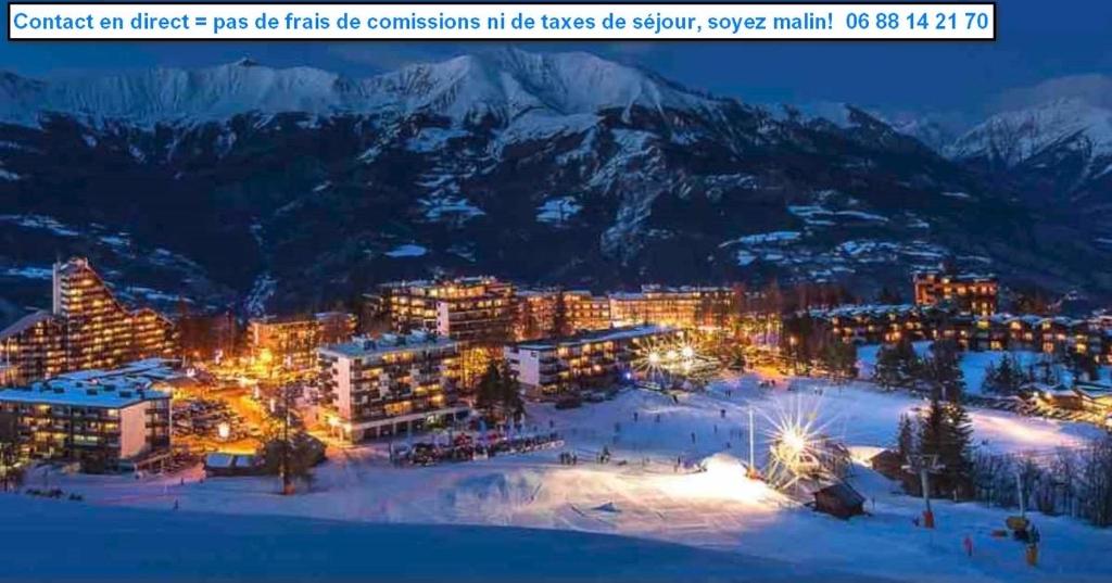 um efeito de luzes em um resort nas montanhas à noite em T2 Immeuble Chanteclerc 6 personnes 37m2 PRALOUP 1600 em Uvernet