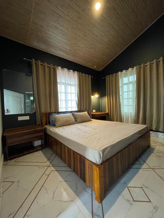 Rilassare stays cottage في Pedong: غرفة نوم بسرير كبير وتلفزيون بشاشة مسطحة