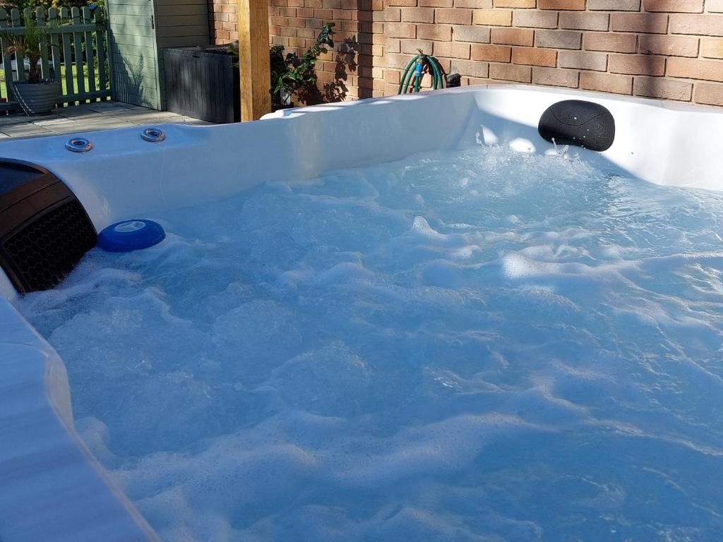 a hot tub filled with water with snow at Woodpeckers - Alresford Essex in Alresford