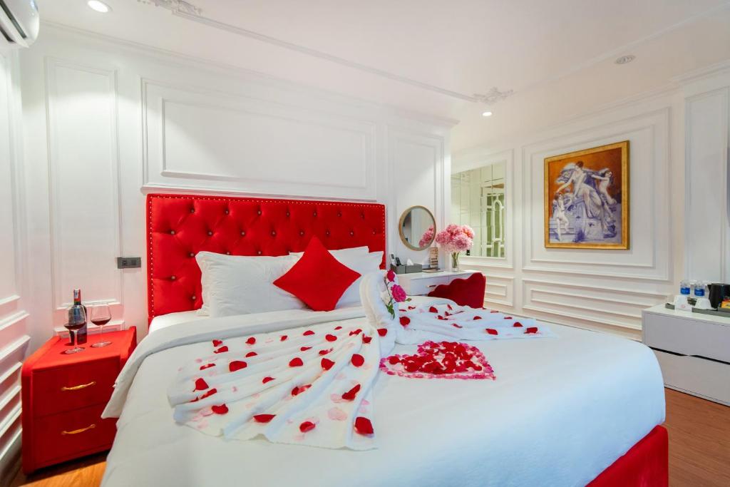 a white bedroom with a red headboard and a bed at Diamond Hotel Sapa in Sapa