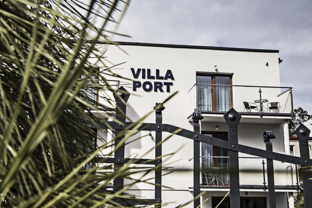 a white building with a villa port sign on it at Villa Port in Iława