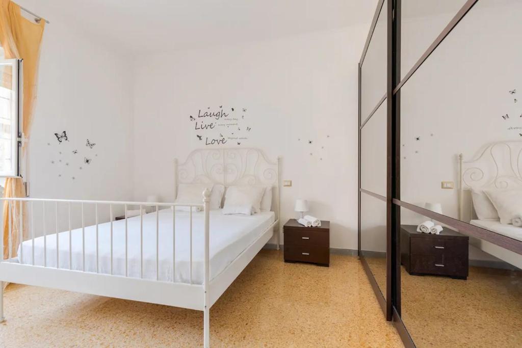a white bedroom with a crib and a mirror at Locazione turistica Roman style near San Pietro in Rome