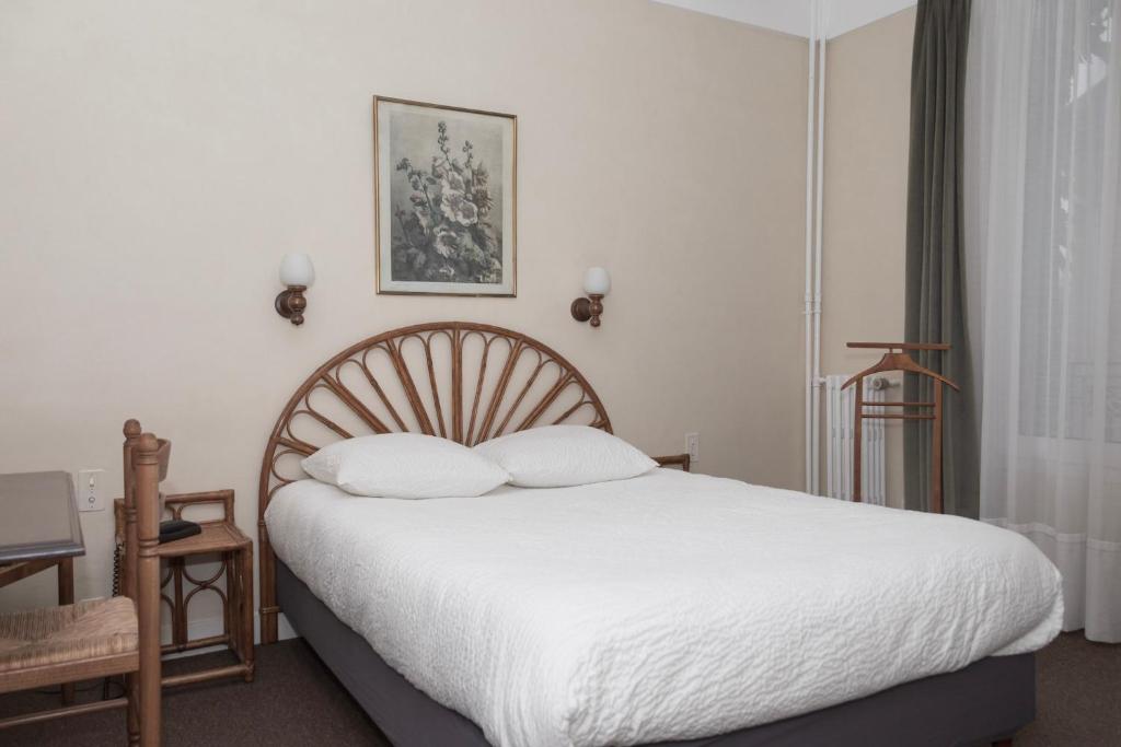 - une chambre avec un grand lit et des draps blancs dans l'établissement Cit'Hotel Aéro-Hotel, au Blanc-Mesnil