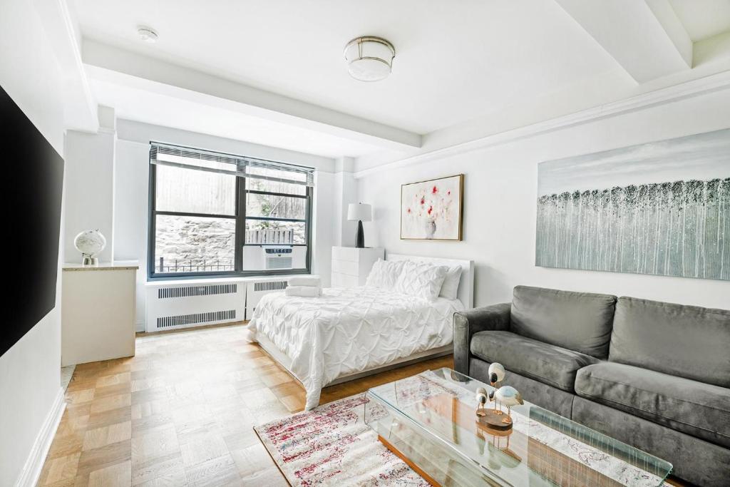 a living room with a couch and a bed at Cozy Studio Apartment in New York