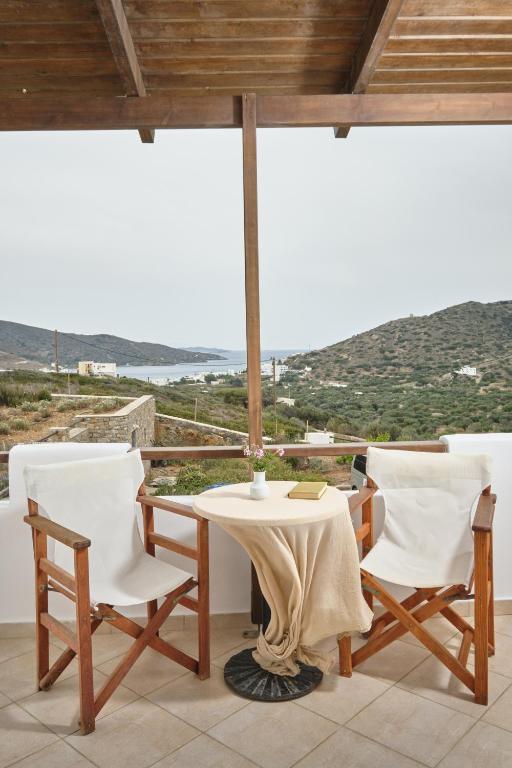 a table and chairs with a view of the ocean at Amorgion Village in Katapola
