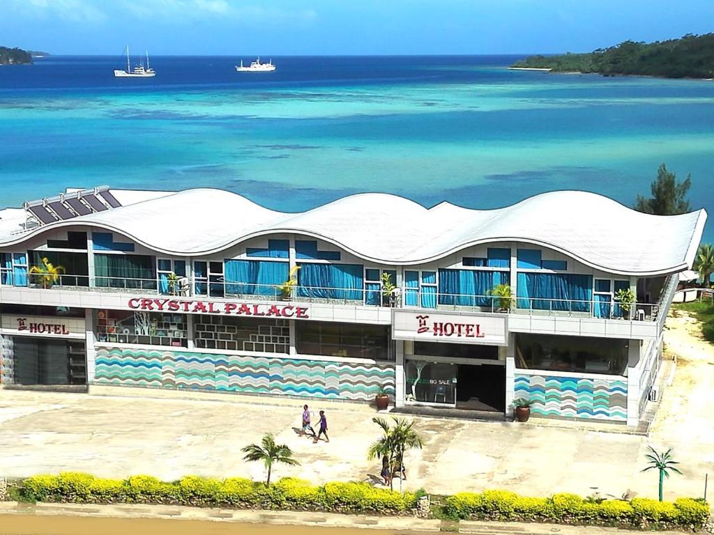 a building on the beach next to the ocean at Crystal Beach Hotel in Port Vila