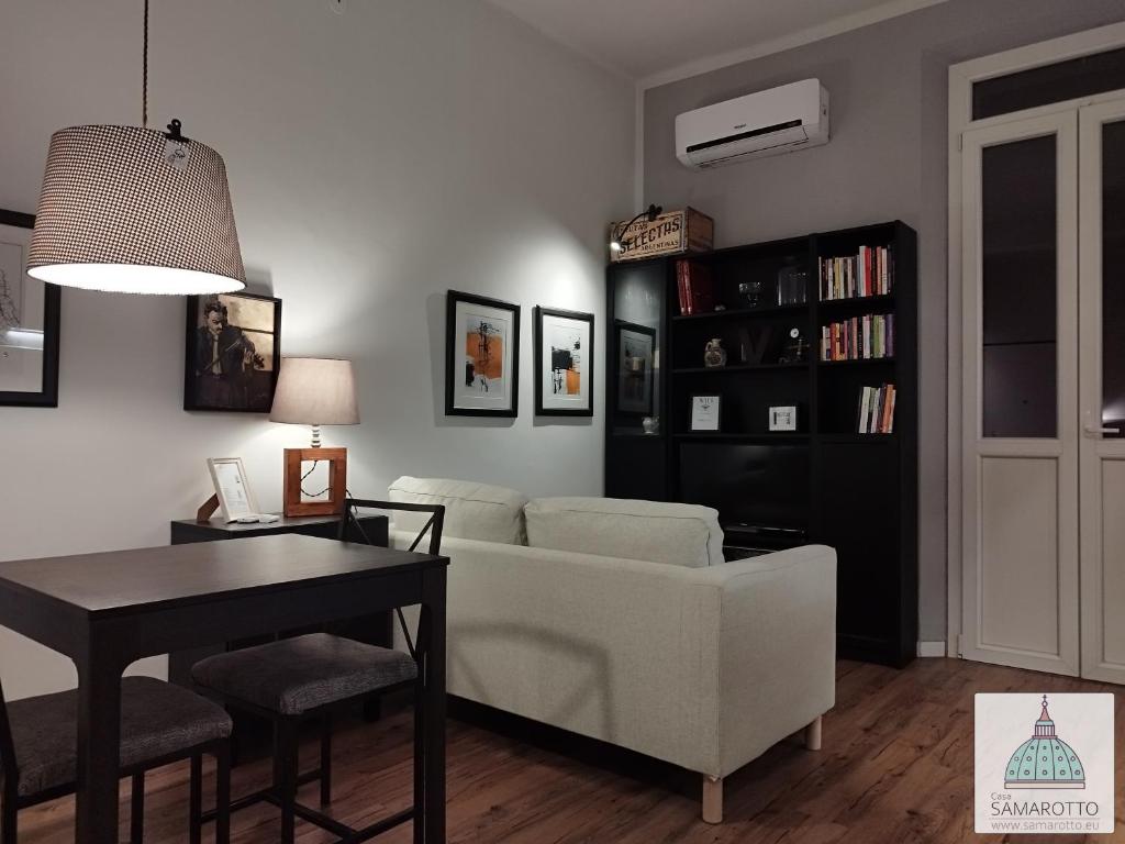 un soggiorno con divano bianco e tavolo di Casa Samarotto a Reggio Emilia