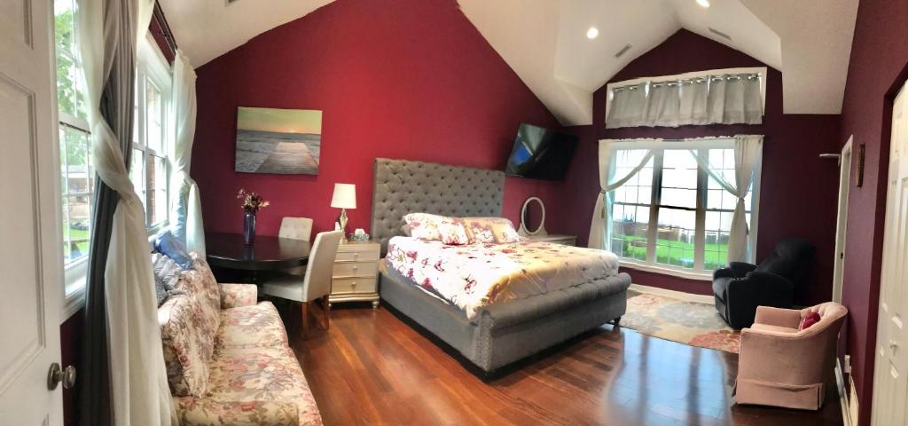 Schlafzimmer mit roten Wänden, einem Bett und einem Schreibtisch in der Unterkunft Waterfront vacation home in Kingsville