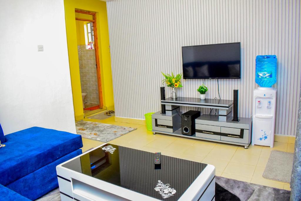 a living room with a blue couch and a flat screen tv at ROYALSTAYCATION in Ruiru