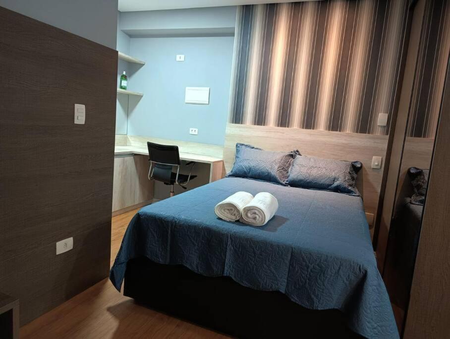 um quarto com uma cama com duas toalhas em Stay GRU - Loft Completo próx GRU airport - Guarulhos em Guarulhos