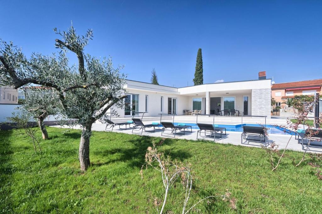 a villa with a swimming pool and a yard at Aura in Pula