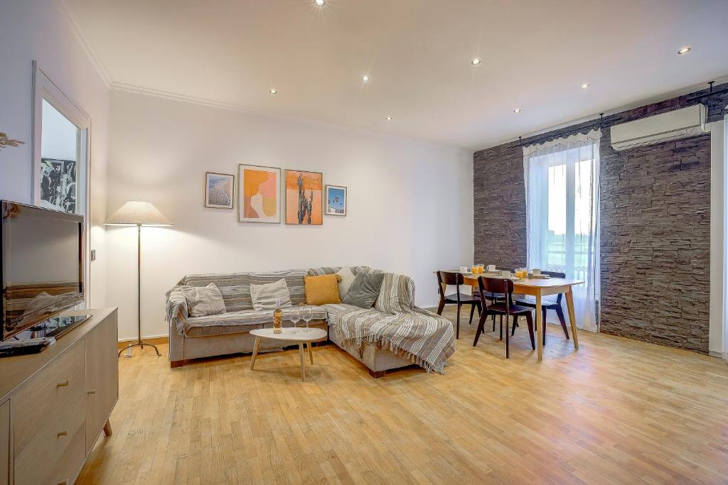 un salon avec un canapé et une table dans l'établissement Maison Bianchi - Chauvain Place Massena, à Nice