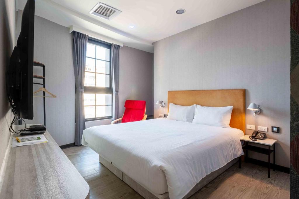 Una cama o camas en una habitación de CHECK inn Taichung Ziyou