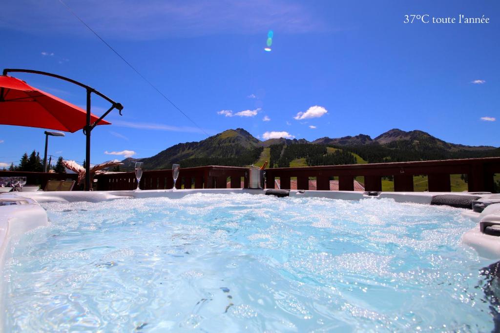 a large hot tub with a view of mountains at Spacious Chalet 16/18 Guests w/Slope View, Jacuzzi et Sauna in Montgenèvre