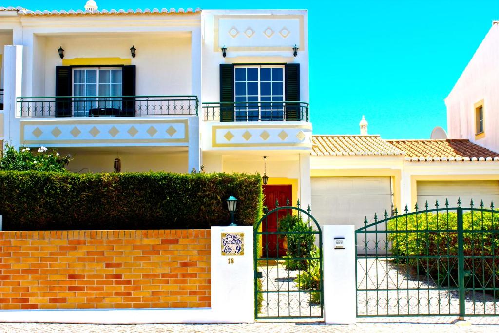 een wit huis met een hek ervoor bij Bella & Gordinho GuestHouse in Lagos