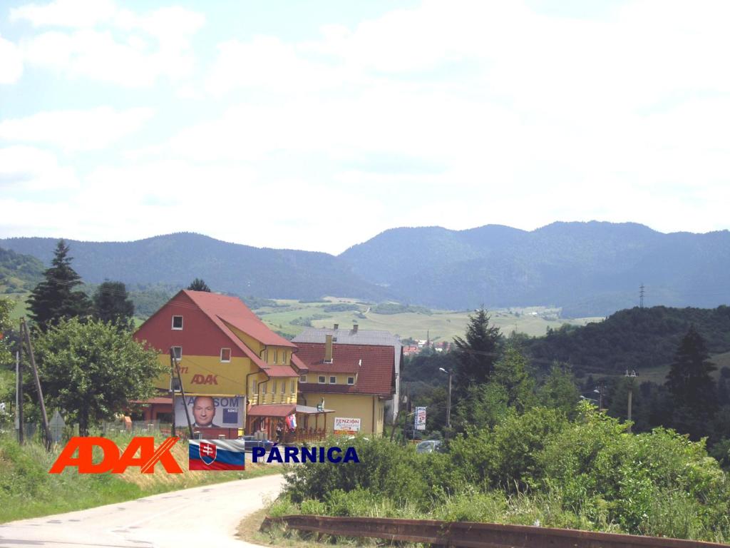 a house with a sign on the side of a road at Penzion Adak in Párnica