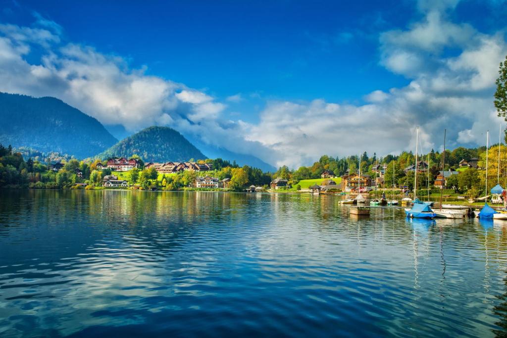 vista su un lago con barche in acqua di MONDI Hotel am Grundlsee a Grundlsee