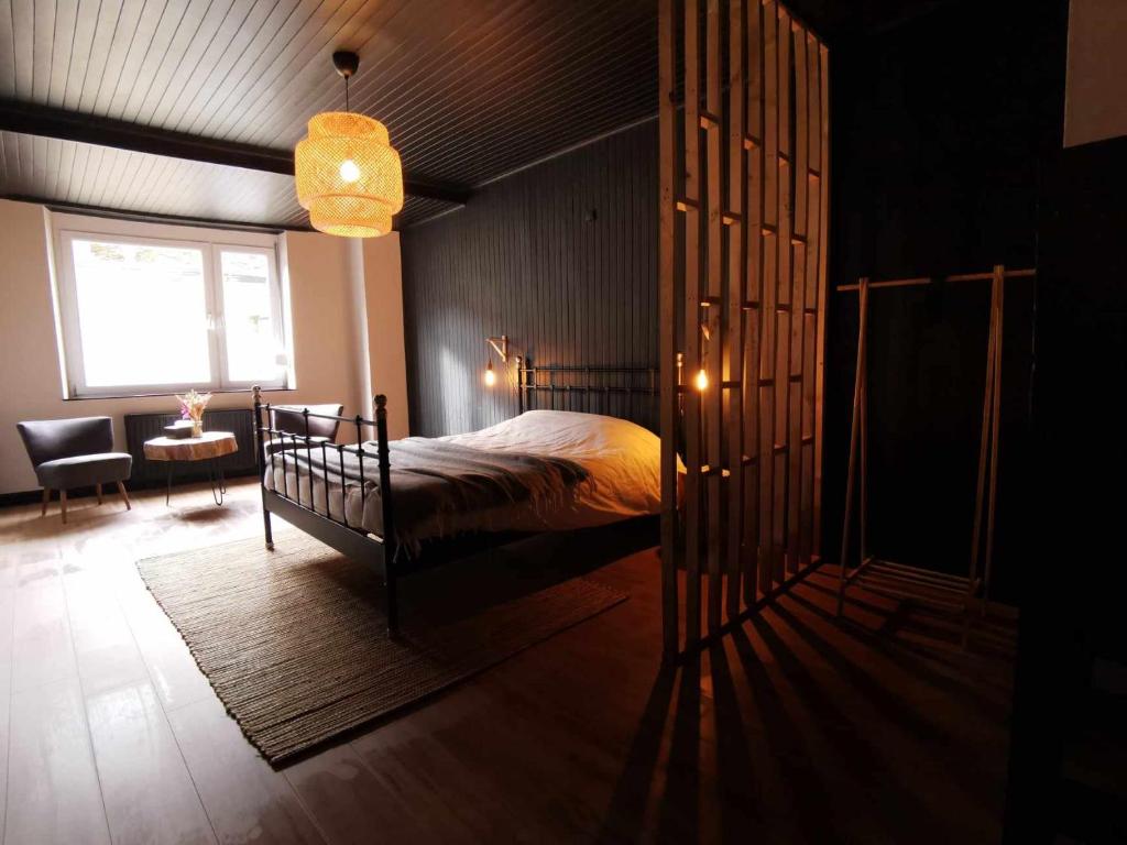 ein Schlafzimmer mit einem Bett und ein Zimmer mit einem Fenster in der Unterkunft Le petit Chermont in Saint-Hubert