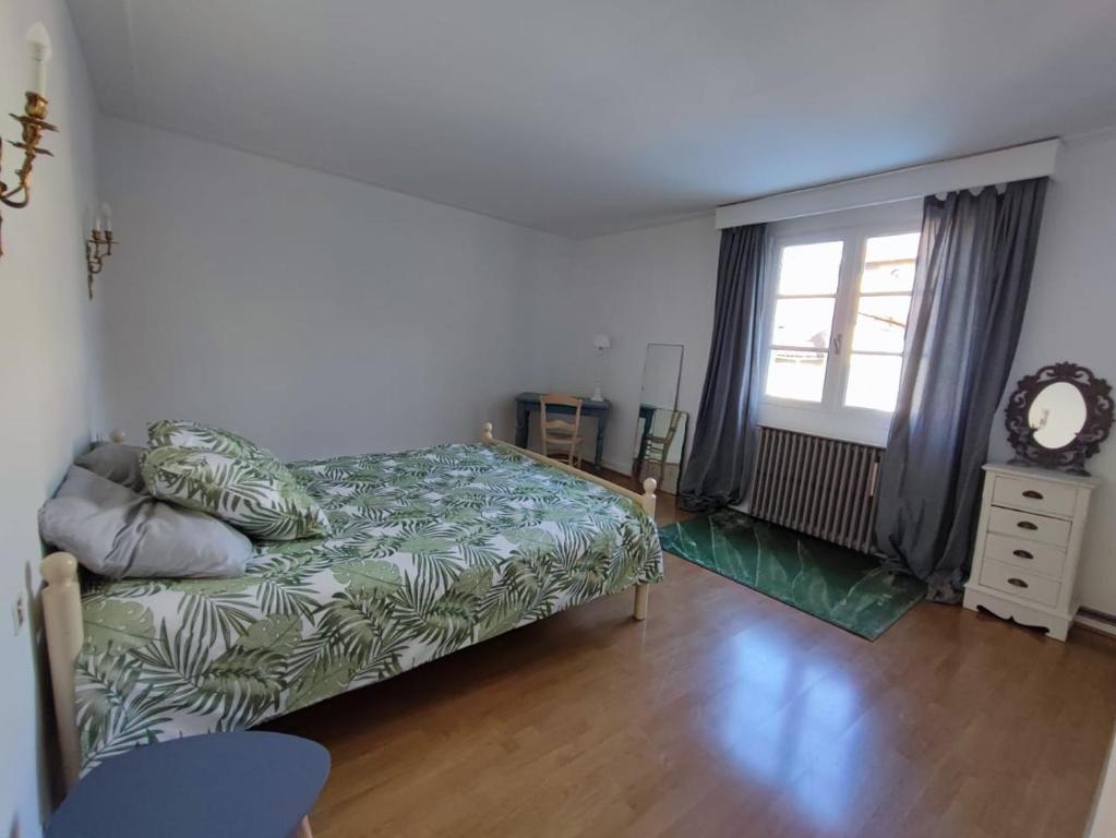 1 dormitorio con cama y ventana en Villa Loha Maison de vacances, en Saint-Gaudens