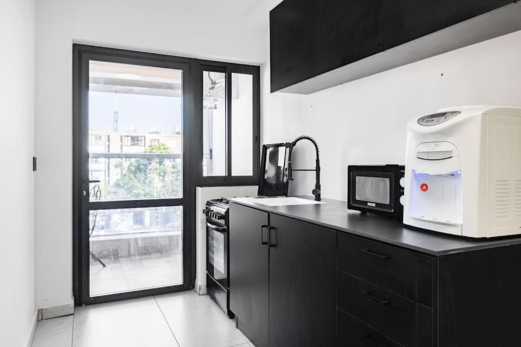 a kitchen with a microwave on a counter and a window at Studio Unit in Ashdod Israel in Ashdod