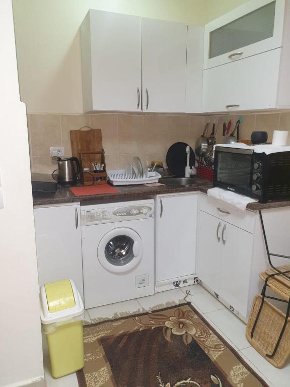 a kitchen with a washing machine and a microwave at مكادى هايتس in Hurghada