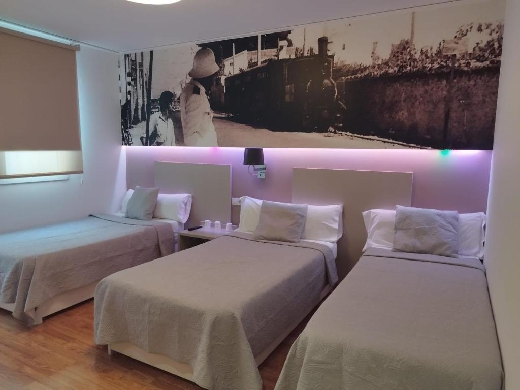 2 camas en una habitación con iluminación rosa en Hello Villarreal Suites, en Villareal