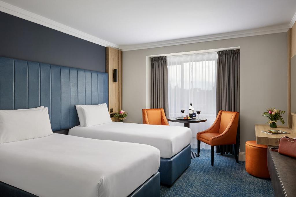 a hotel room with two beds and a desk at Springfield Hotel in Leixlip