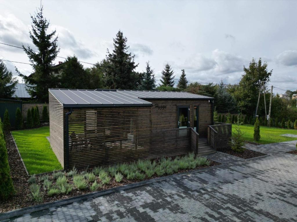 un pequeño edificio de madera con techo solar en Lawendowe Domki Latoszyn-Zdrój Domek Hygge, en Latoszyn