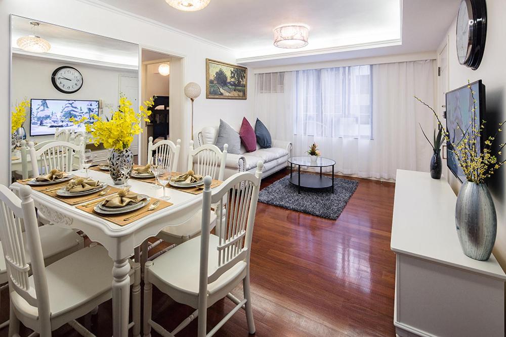 ein Esszimmer und ein Wohnzimmer mit einem Tisch und Stühlen in der Unterkunft Tsim ShaTsui Luxury 3bedroom Apartment near MTR！ in Hongkong