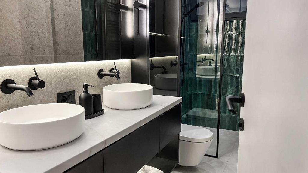 a bathroom with two sinks and a glass shower at ZEST Verde in Kragujevac