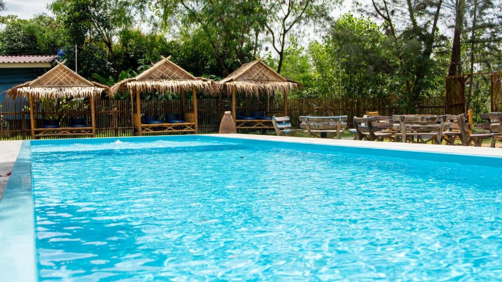 a large blue swimming pool with chairs and umbrellas at DolceVita Wonderful Resort in Ko Lanta