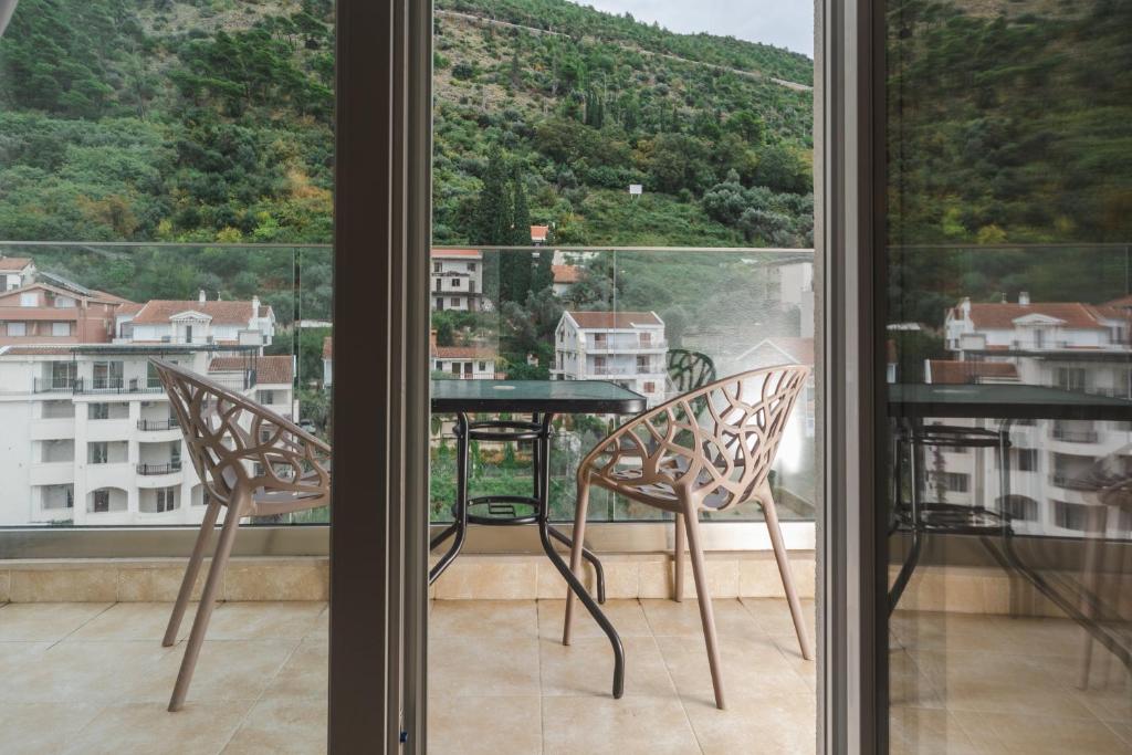 ブドヴァにあるHotel 219 Budvaの窓の前にテーブルと椅子が備わるバルコニー