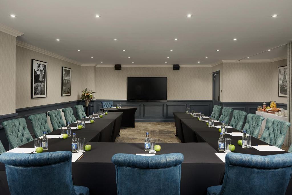 a conference room with tables and chairs and a screen at Springfield Hotel in Leixlip