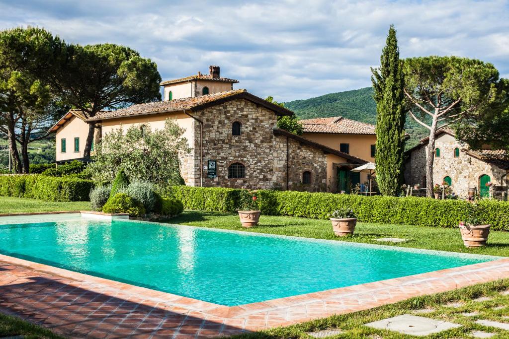 una finca con piscina frente a una casa en Viticcio en Greve in Chianti