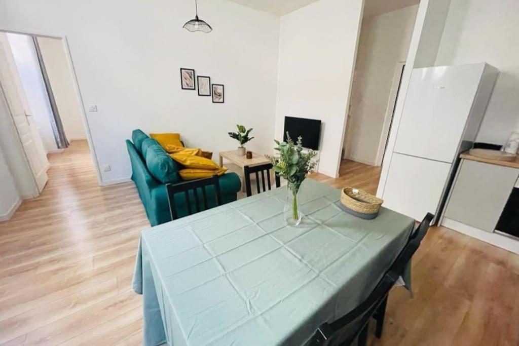 - un salon avec une table et un canapé vert dans l'établissement Superbe T3 en centre-ville et facile d'accès, à Orléans