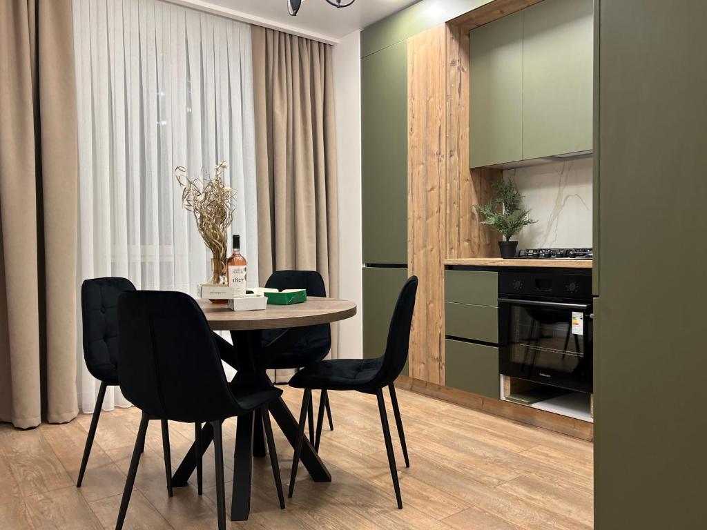 uma sala de jantar com uma mesa e cadeiras pretas em Renthouse Apartments Level Up em Chisinau
