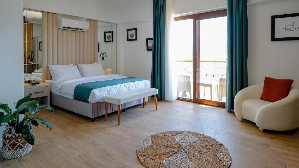 a bedroom with a bed and a couch and a chair at Marina Port Akyaka in Muğla