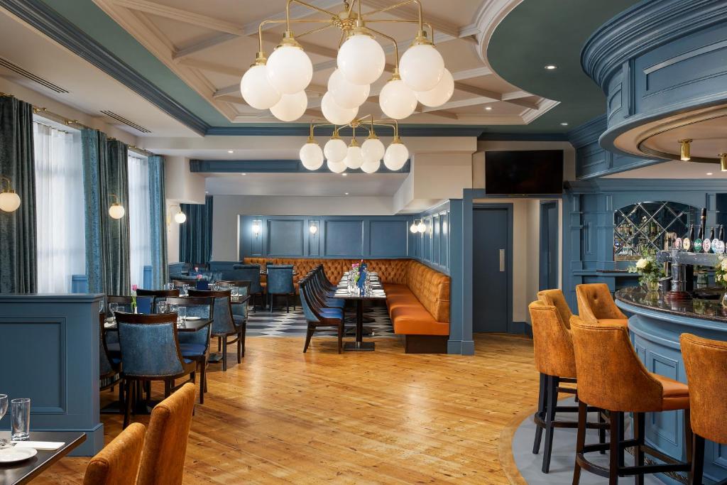 a restaurant with tables and chairs and a bar at Springfield Hotel in Leixlip
