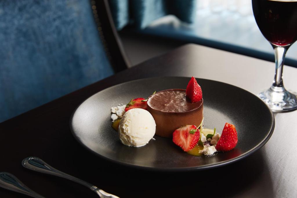 a plate with a chocolate dessert and ice cream and strawberries at Springfield Hotel in Leixlip