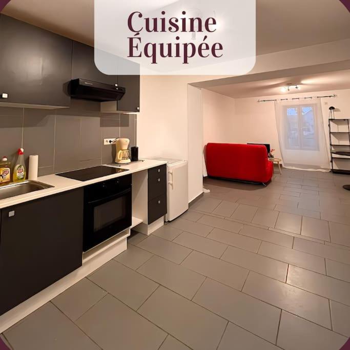 uma cozinha com um sofá vermelho no meio em Appartement 1er étage calme parking gratuit à 1 min à pieds em Roanne